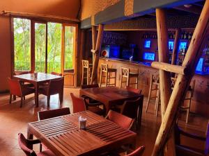 a restaurant with tables and chairs and a bar at Babylon Lodge in Marangu