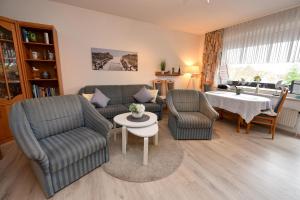 uma sala de estar com duas cadeiras e uma mesa em Haus "Luv und Lee" Appartement LUV31 em Cuxhaven