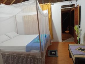 - une chambre avec un lit à baldaquin dans l'établissement Lalosi Homestay, à Besir