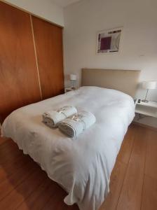 1 cama blanca grande con 2 toallas plegables. en Departamento amplio y moderno de 1 dormitorio céntrico 11 esq 60 en La Plata