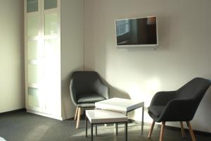 a room with two chairs and a tv on a wall at Restaurant Ollex and beds Zimmer 2 in Bliesdorf