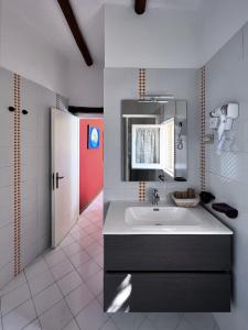 a bathroom with a sink and a red door at Aeneas' Landing Resort in Gaeta