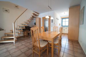 - une cuisine et une salle à manger avec une table et des escaliers dans l'établissement Reetdachhaus Malve 2, à Puddemin