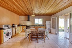 a kitchen with a table and chairs and a kitchen with a stove at le paradis d'Elise in Cilaos