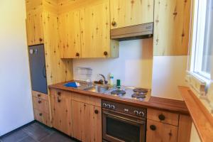 una cocina con armarios de madera y fregadero en Miraflor Carmen - Arosa Holiday, en Arosa