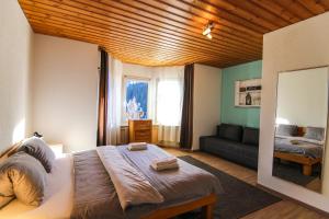 a bedroom with a large bed and a couch at Miraflor Carmen - Arosa Holiday in Arosa