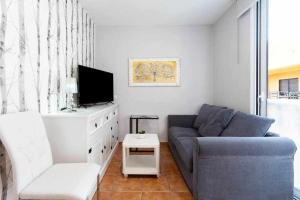 a living room with a blue couch and a tv at Sunnyland Las Teresitas 3 in San Andrés