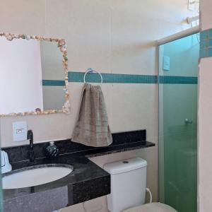 W łazience znajduje się umywalka, toaleta i lustro. w obiekcie Pousada Abreu do Una w mieście São José da Coroa Grande