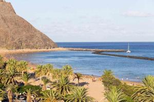 een strand met palmbomen en een boot in het water bij Sunny Island Las Teresitas 3 in San Andrés