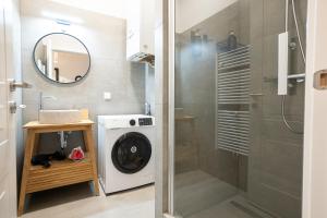 a bathroom with a washing machine and a mirror at Brand new 2-room central apartment in Vienna