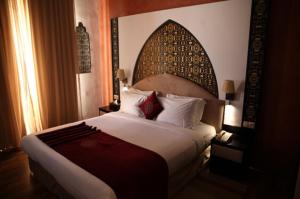 a bedroom with a large bed with a large headboard at El Minzah Hotel in Tangier