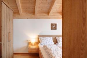 a bedroom with a bed and a wooden ceiling at Ferienwohnung Gletschernelke in Grainau