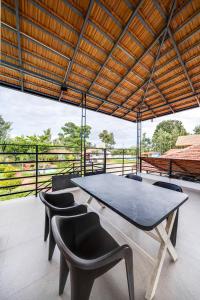 uma grande mesa e cadeiras num quarto com vista em Hatti Eden Coorg em Gonikoppal