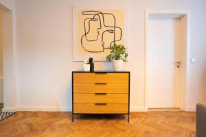 a dresser with a plant on top of it in a room at Brand new 2-room central apartment in Vienna