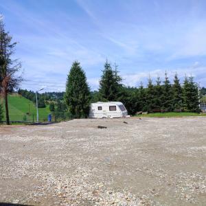 a white trailer parked in a parking lot at Tatrzański Camper Park- parcele kamperowe in Bukowina Tatrzańska