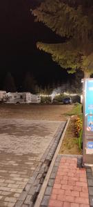 um autocarro estacionado num parque de estacionamento à noite em Tatrzański Camper Park- parcele kamperowe em Bukowina Tatrzańska