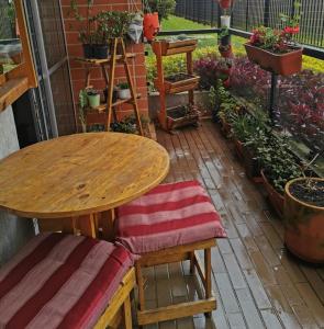 uma mesa de madeira e cadeiras num jardim em Tu mejor decisión a 20 minutos de Bogotá. em Mosquera