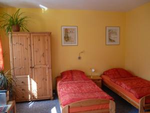 1 Schlafzimmer mit 2 Einzelbetten und einem Schrank in der Unterkunft Ferienwohnungen Am Breitstrom in Erfurt
