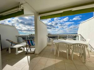 een balkon met een tafel en stoelen op een balkon bij PGH N25 - Vue Mer, Première Ligne & Parking Privé in La Grande-Motte