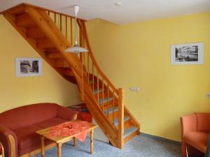 a living room with a couch and a wooden staircase at Ferienwohnungen Am Breitstrom in Erfurt +22 photos