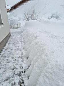 een berg sneeuw aan de zijkant van een huis bij Ferienhaus Ritzmais in Bischofsmais