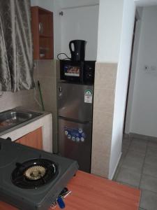 a small kitchen with a sink and a refrigerator at REMA AIRBNB'S in Nairobi