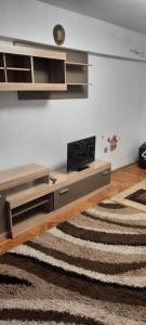 a living room with a desk with a television and a rug at Apartament in Craiova