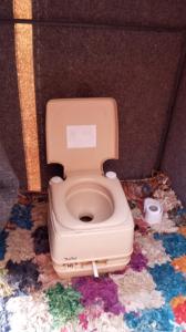 a toilet sitting in a room with a colorful floor at Gambe Camp in Adrouine