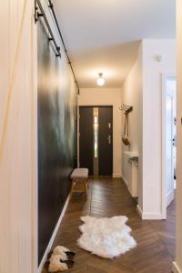 a hallway with a black wall and a rug on the floor at VacationClub - Spokojna 24E Apartament B1 in Wisła