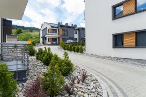 a house with a garden and a driveway at VacationClub - Spokojna 24E Apartament B1 in Wisła