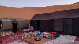 a large black tent with tables and chairs in it at Gambe Camp in Hassilabied