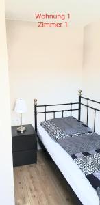 a bedroom with a bed and a table with a lamp at 2x Monteurwohnung 1x 2 kleine Einzelzimmer 1x Doppelbett und Schlafcouch im Wohnbereich in Siegen