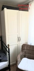 una camera con una porta, una sedia in rattan e una finestra di 2x Monteurwohnung 1x 2 kleine Einzelzimmer 1x Doppelbett und Schlafcouch im Wohnbereich a Siegen
