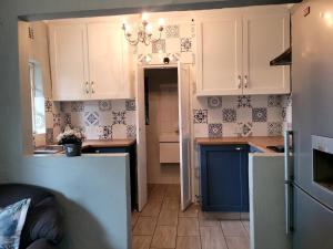 a kitchen with white cabinets and a blue refrigerator at City Gate Two in Pietermaritzburg