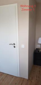 a white door in a room with a lamp at 2x Monteurwohnung 1x 2 kleine Einzelzimmer 1x Doppelbett und Schlafcouch im Wohnbereich in Siegen +19 photos