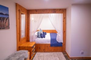 a bedroom with a bed and a window at Tigh Lachie at Mary's Thatched Cottages, Elgol, Isle of Skye in Elgol