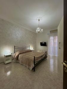 1 dormitorio con cama y lámpara de araña en Barbi’s House, en Nápoles