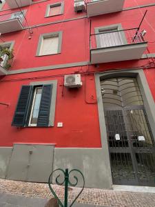un edificio rojo con puerta y ventana en Barbi’s House, en Nápoles