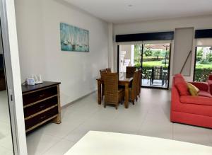 a living room with a red couch and a table at Private Modern Condo by Jac Beach in Jacó