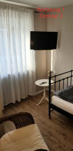 ジーゲンにある2x Monteurwohnung 1x 2 kleine Einzelzimmer 1x Doppelbett und Schlafcouch im Wohnbereichのベッド2台、テーブル、窓が備わる客室です。