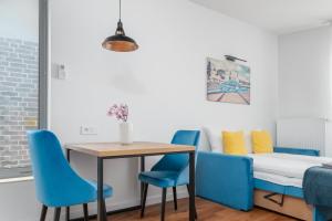 una sala da pranzo con sedie blu, tavolo e letto di Apartament Figo a Stettino
