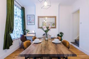 a dining room with a wooden table and chairs at Stylish 3Bed Retreat - Walk to Coventry's Delights in Coventry