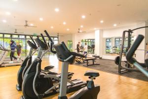 - une salle de sport avec des appareils de cardio-training et des personnes en arrière-plan dans l'établissement FxA Studios Core Soho Suites KLIA 1 & 2 FREE WIFI, à Sepang