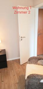 a room with two beds and a white door at 2x Monteurwohnung 1x 2 kleine Einzelzimmer 1x Doppelbett und Schlafcouch im Wohnbereich in Siegen