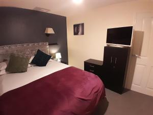 a bedroom with a bed and a flat screen tv at Silverstone White House in Silverstone