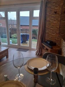 a table with two wine glasses on top of it at Silverstone White House in Silverstone