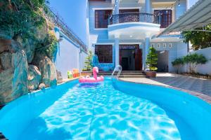 a pool in front of a house with a pink pool noodle at Sea Villa Hồ Bơi Gần Biển Bãi Sau - Free Karaoke + Bida in Vung Tau