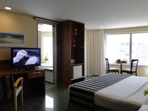 una camera d'albergo con letto e TV di Costa do Mar Hotel a Fortaleza