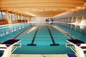 une grande piscine intérieure d'eau bleue dans l'établissement Akadémia Hotel, à Balatonfüred
