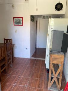 uma sala de estar com piso em madeira e uma cozinha em Departamentos mora em Santa Teresita